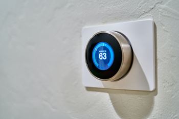 an image of a remote control plugged into a wifi thermostat on a wall